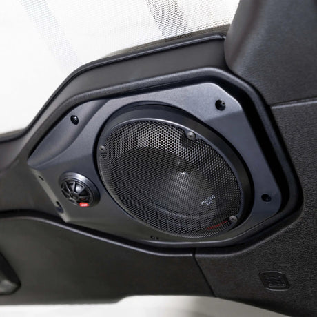 Installed round speaker grille and small tweeter in a black molded vehicle speaker pod