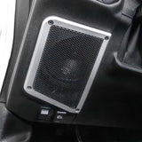 Installed subwoofer enclosure with a round mesh grille and silver mounting frame
