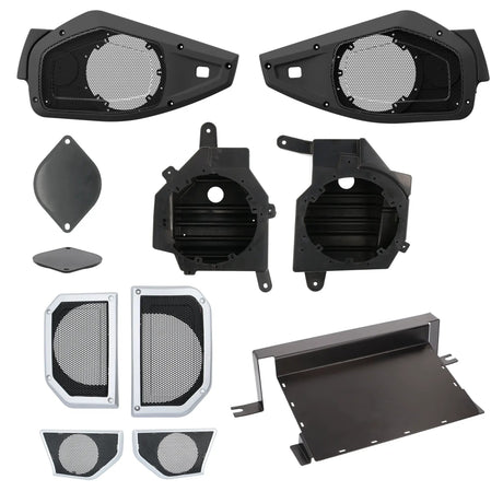 Speaker mounting housings and trim panels with replacement grilles and an amplifier mounting tray