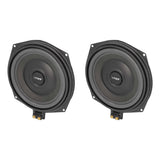 Pair of black VIBE speakers viewed at an angle, showing their cones and lower terminals