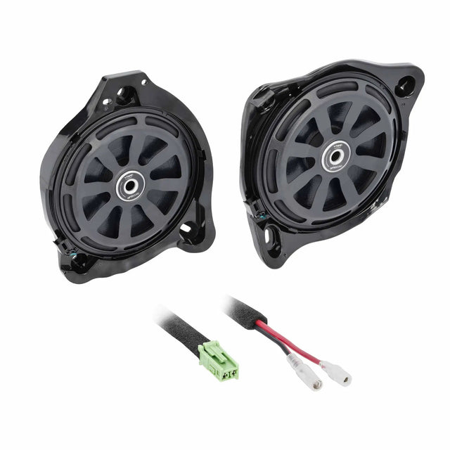 Two shallow speakers with protective grilles and green-plug wiring adapters