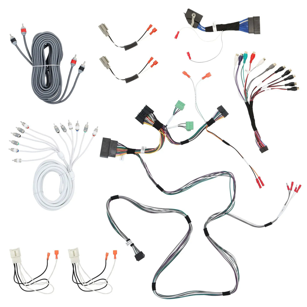 Audio wiring harnesses, coiled RCA cables and speaker adapters arranged on white